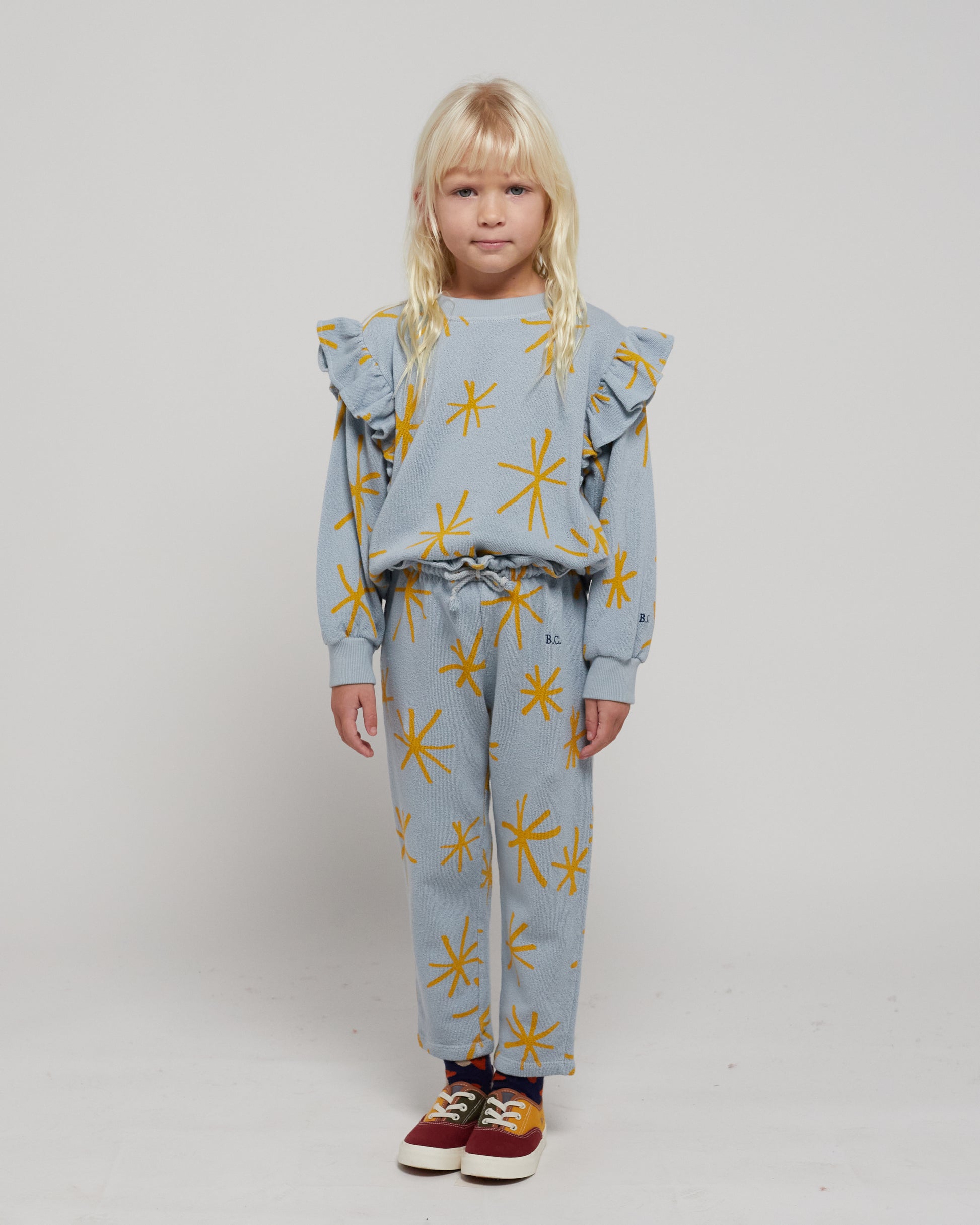 Sparkle Jogging Pants by Bobo Choses. 100% BCI cotton powder blue jogging pants with yellow sparkle print. Designed with adjustable ruffled waistband, ankle length and sooo soft inside. It has a baggy fit. Made ethically and sustainably in Portugal for Bobo Choses.