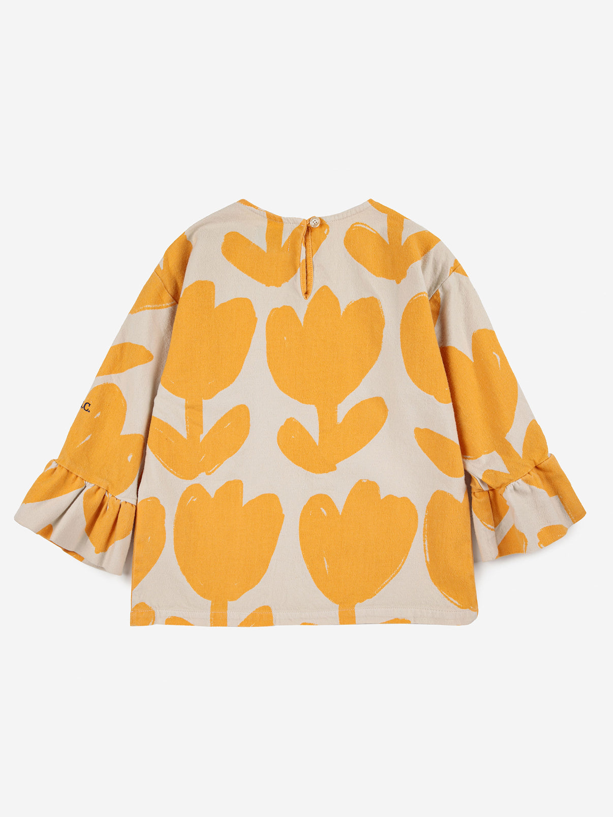 Bobo Choses Big Flower Ruffle Blouse. 100% cotton off white blouse with yellow flowers. Designed with long sleeves, back button fastening, embroidery, round neck and ruffled detailing. It has a evasé fit.  Sustainably and ethically made in Spain.