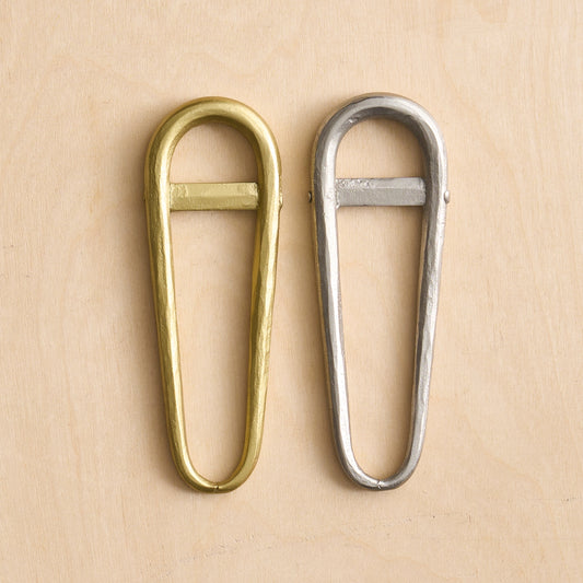 These snowshoe-shaped bottle openers are mightier than they appear. Heavy gauge mild steel wire is hammered, then given a brass or pewter finish that works with any decor. The low-profile, recurving design allows them to be hung from a hook or keychain for frequent use.