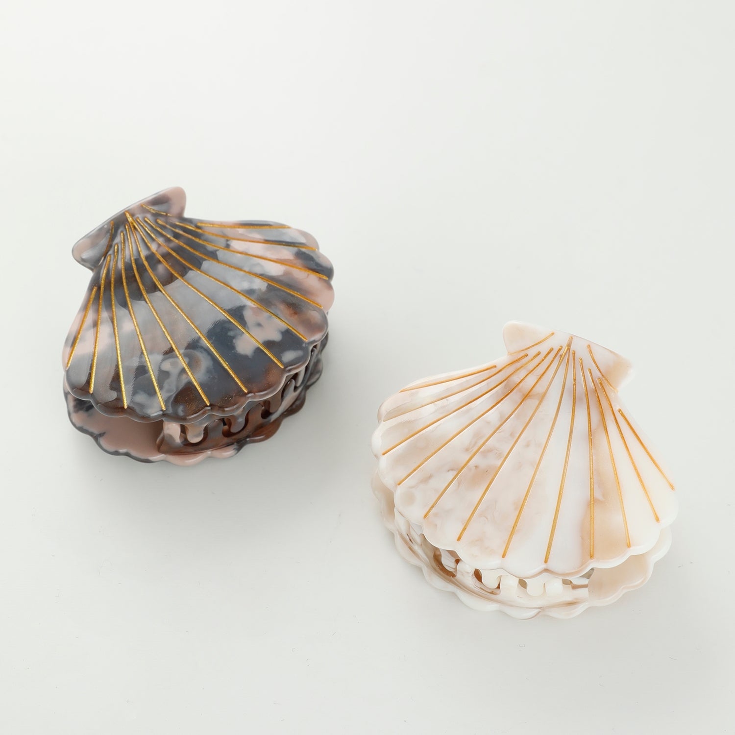 These seashell claw clips feature hand-painted details with a warm, earthy marbled texture. Made with eco-friendly material that is both durable and comfortable.