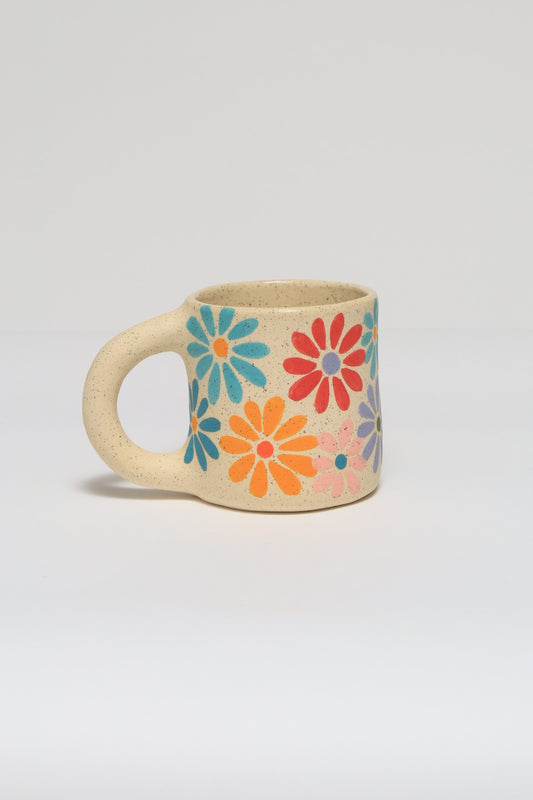 Handmade ceramic mug featuring a hand painted flower design in colorful underglaze. melville ceramics
