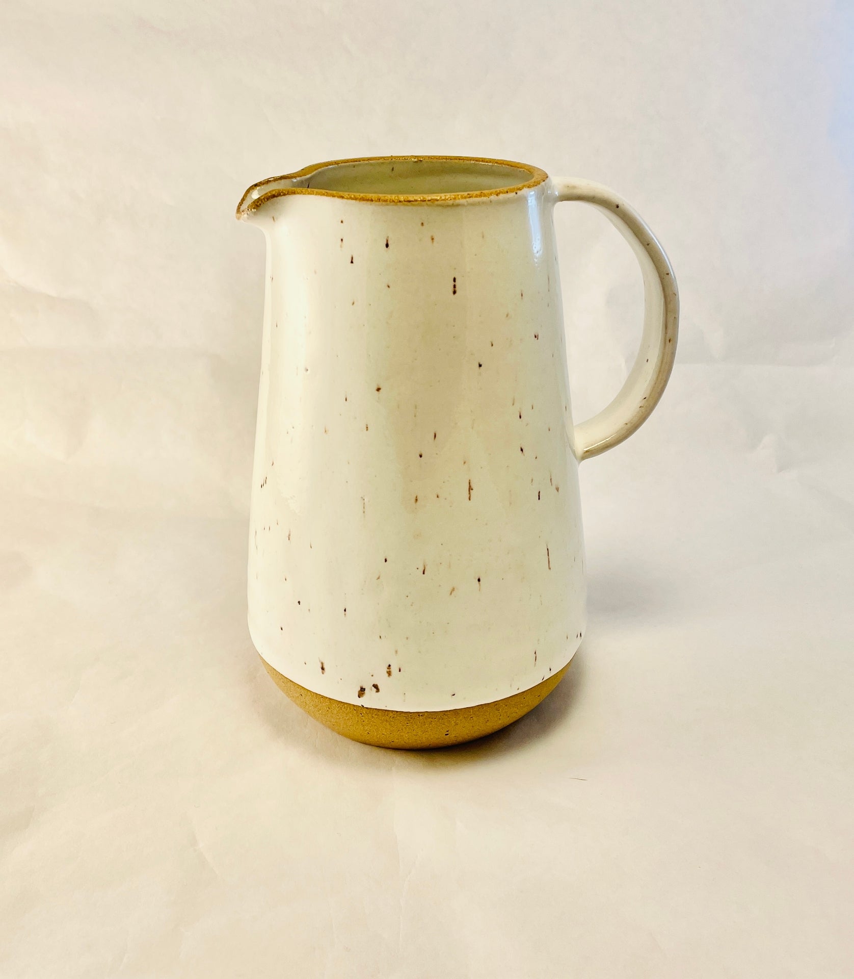 Wheel thrown, tall beverage pitcher with handle. It would also makes a lovely vase. Each item is made individually in Olympia, Washington.