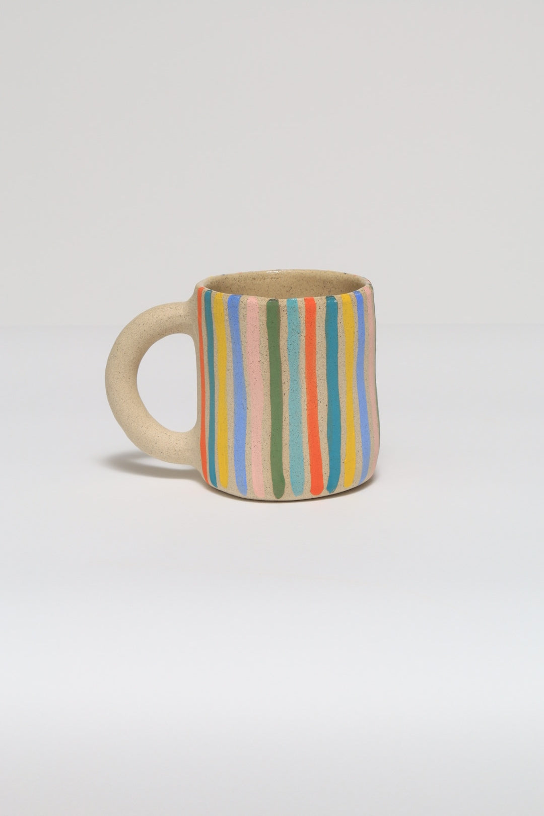 Ceramic mug with striped pattern on a light gray background