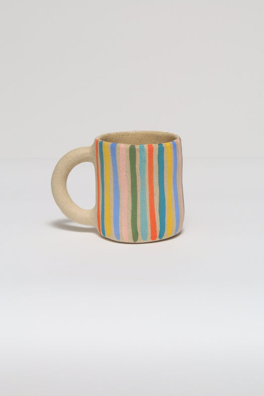 Ceramic mug with striped pattern on a light gray background