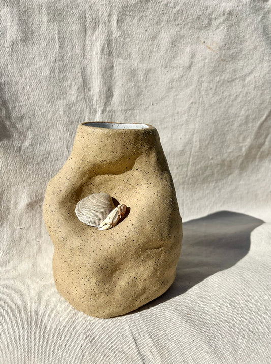 An organic vase with a speckled, textured clay body and white glaze on the inside. A vase for your fresh or dried flowers, yes… but also an alcove to place a teeny treasure to compliment them. Hand built, glazed and fired in Slo, Ca.