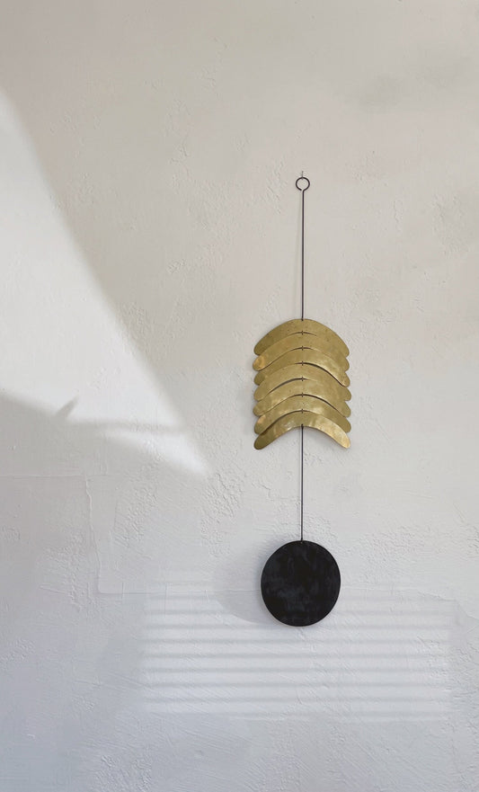 Reversible wall hanging made of manipulated brass shapes cut from brass sheet (with antiqued finish) + a charcoal patinated brass circle. Pieces are coated with a wax, for longevity of finish. Handmade in NorCal, by Electric Sun Creatives