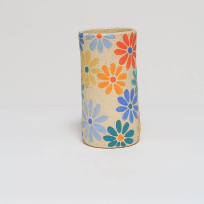Handmade ceramic vase featuring a colorful hand painted flower design.