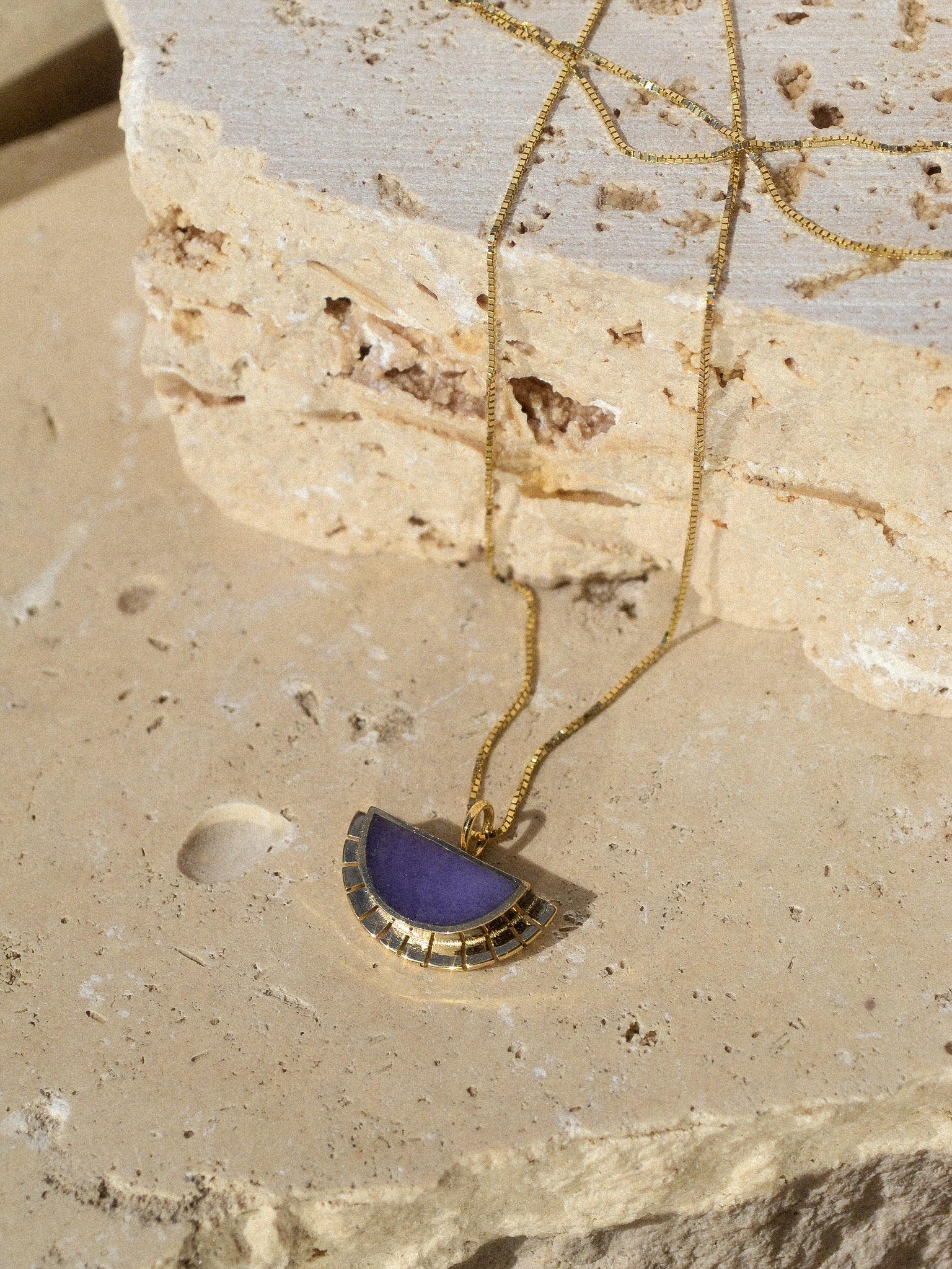 young in the mountains / A half circle of warm 14k yellow gold is wrapped around an inlaid Burro Creek Jasper stone while a serrated halo of light radiates from this sun. This pendant hangs freely on a 14k yellow gold box chain