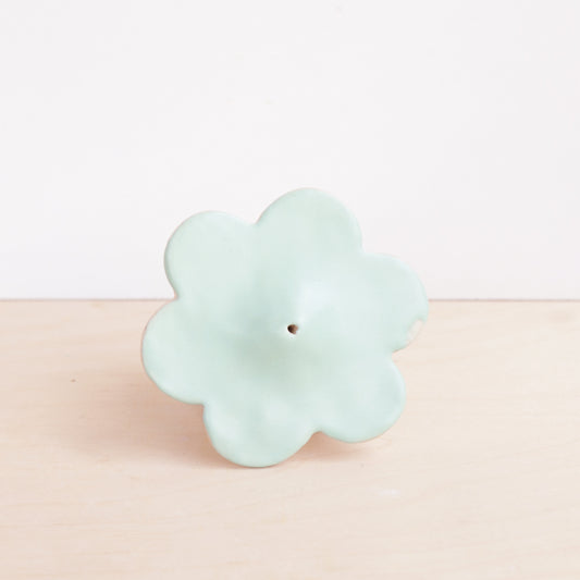 Modern, minimalist incense holder in a simple floral design. A bright satin glaze finishes the piece.