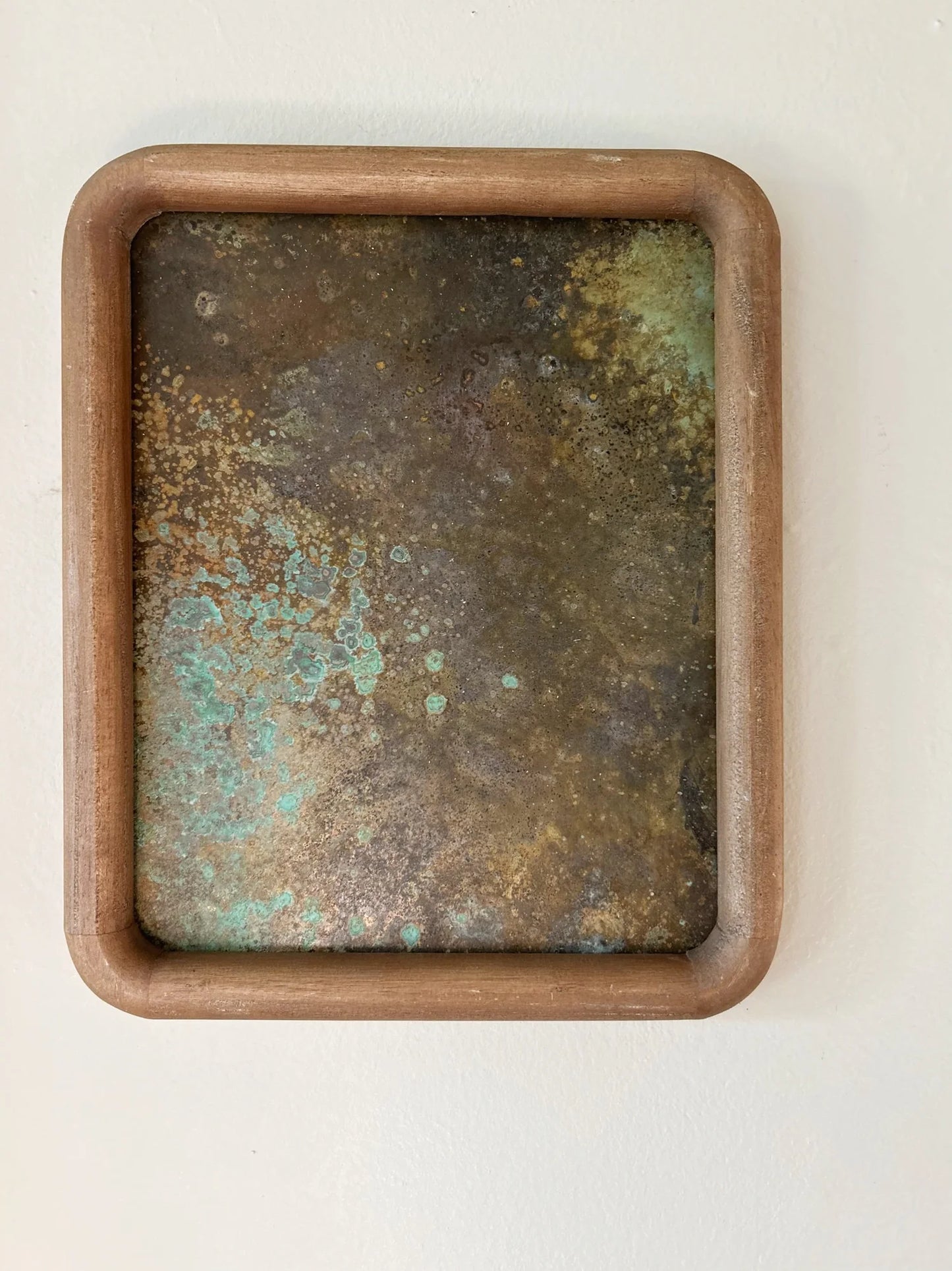 Rust-colored patinated brass sheet set in a rounded wood frame. by electric sun creatives sarah perez