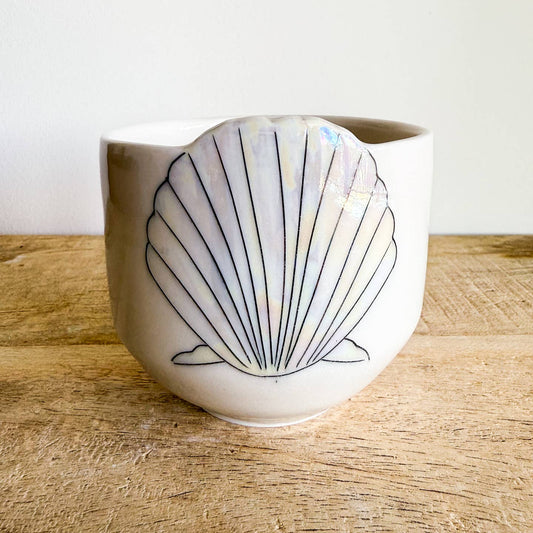 Seashell cups are hand-thrown from fine porcelain, and feature hand drawn inlay and mother of pearl luster for a delicate and iridescent shine.
