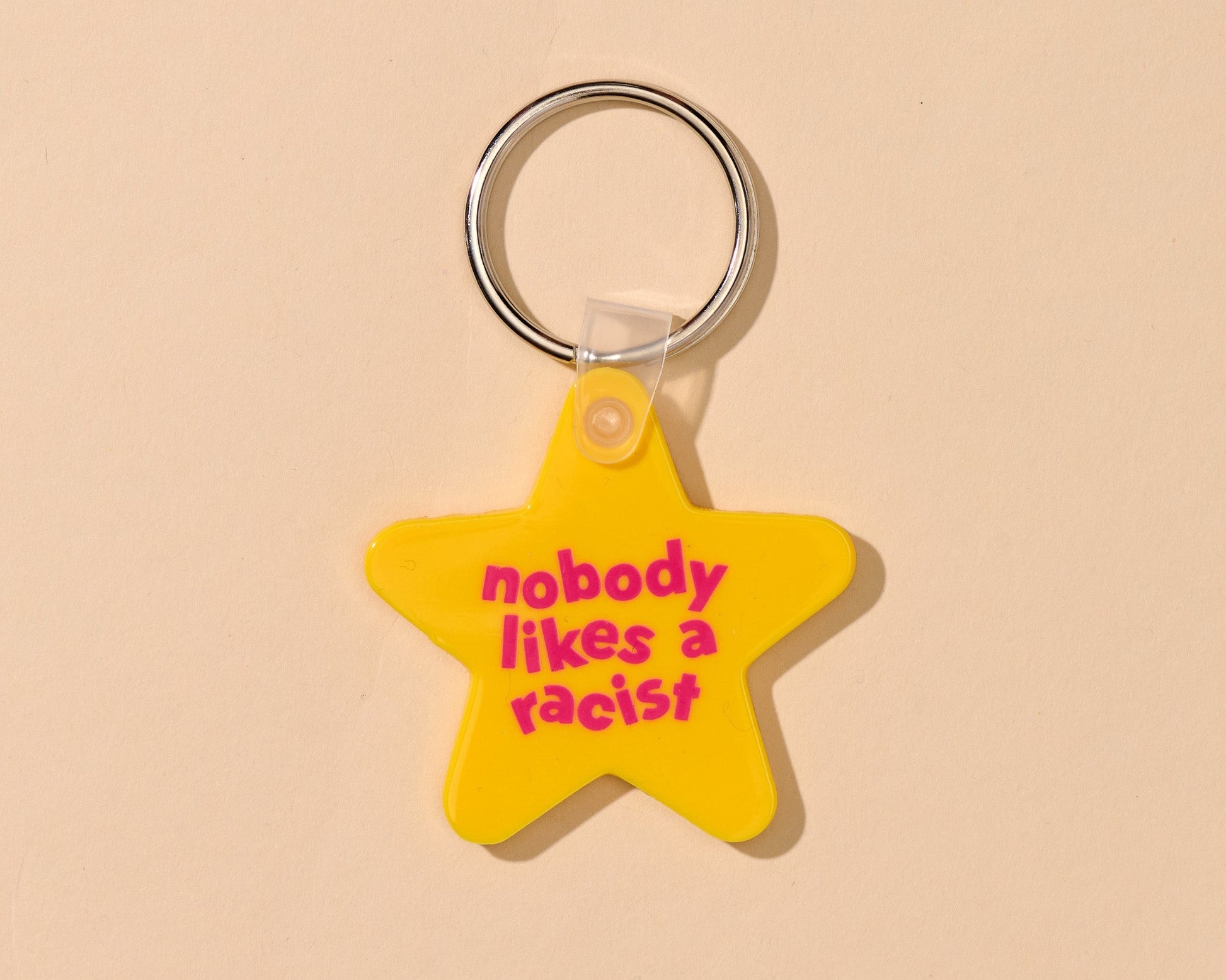 "Nobody Likes A Racist" yellow stair keychain. Made from PVC.