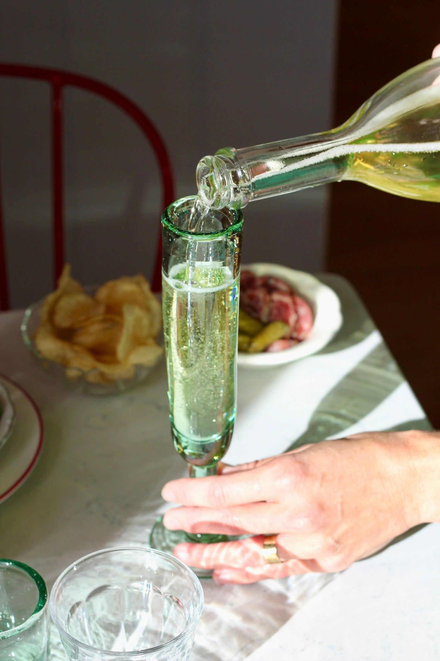 A playful champagne flute with a unique silhouette, designed to keep the party going. Each glass is handmade from recycled glass by artisan partners in Bogotá, Colombia, giving every piece its own subtle character.