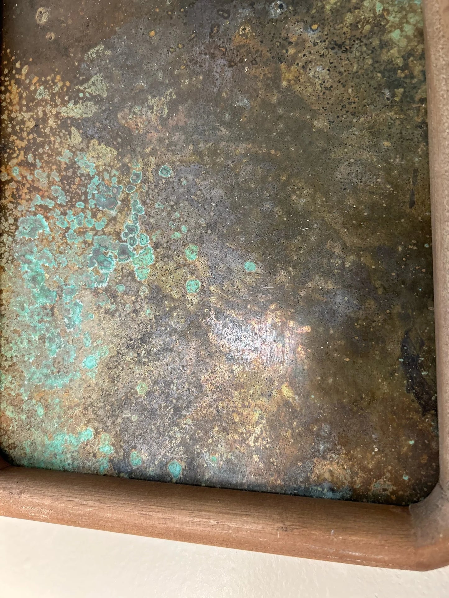 Rust-colored patinated brass sheet set in a rounded wood frame. by electric sun creatives sarah perez