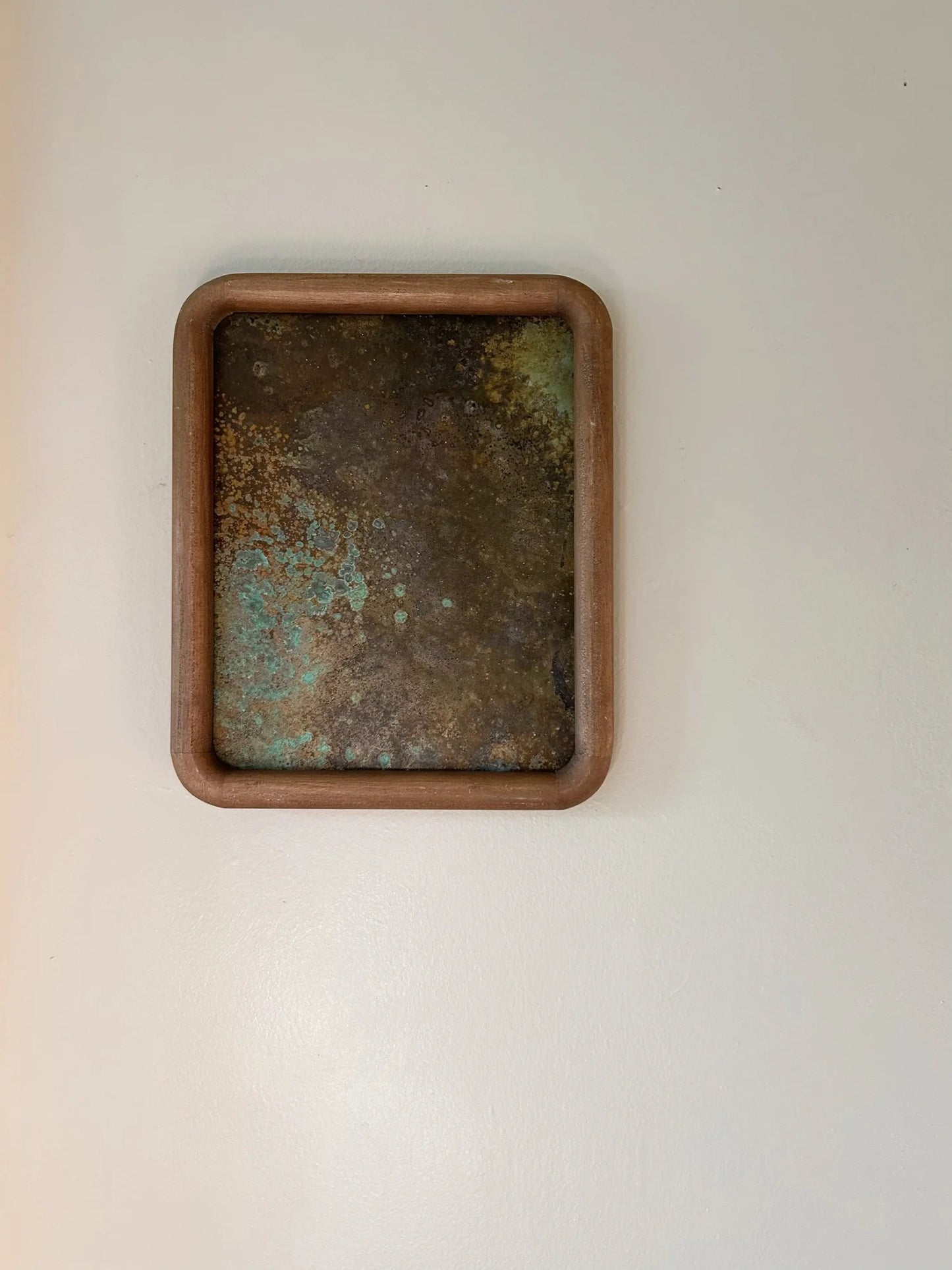 Rust-colored patinated brass sheet set in a rounded wood frame. by electric sun creatives sarah perez