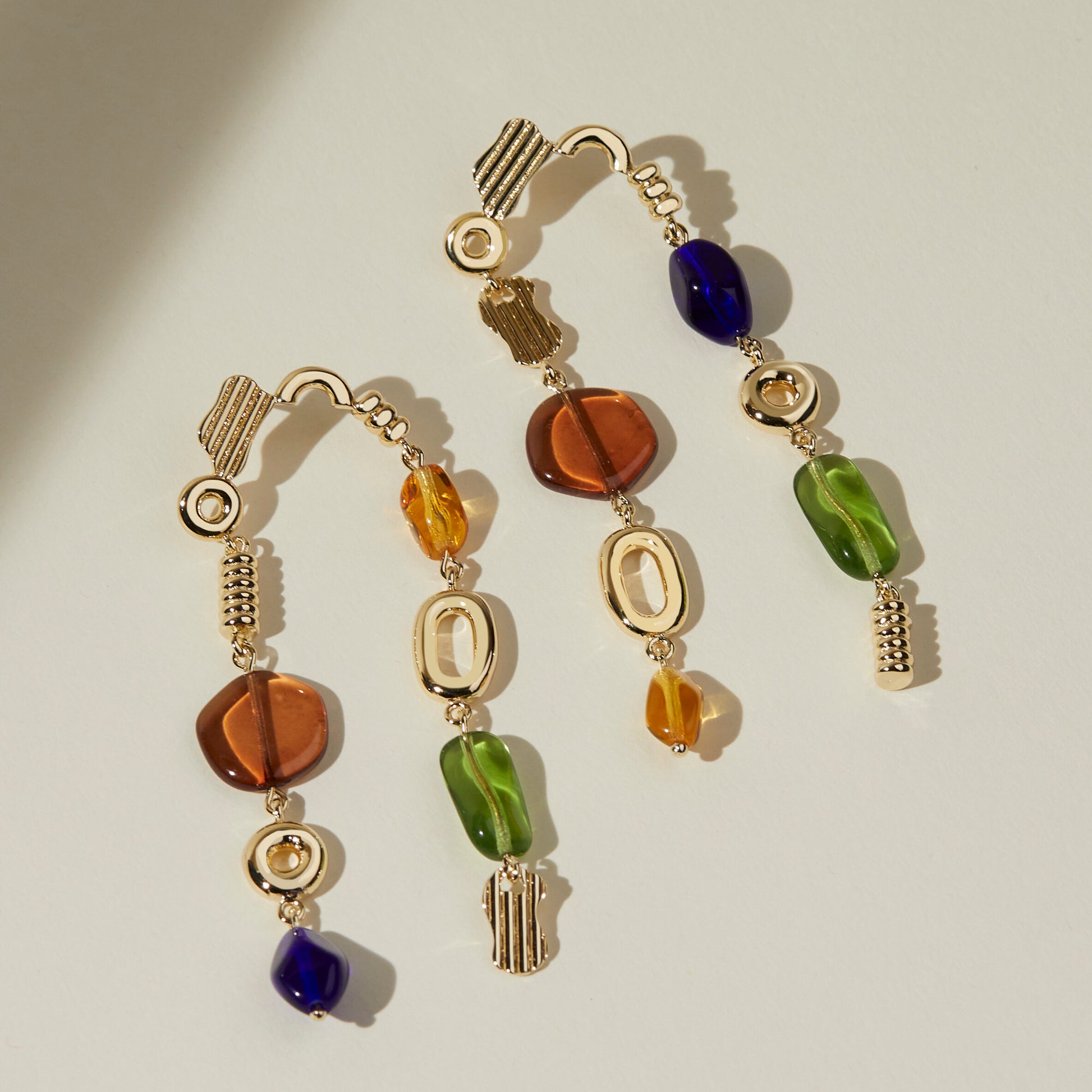 Features 8 colored glass beads that glisten in sunlight. Each metal charm is cast, polished, and assembled by hand. These stunning earrings almost dust your shoulders at 3” long. Available in two colorways. Handmade in the USA by Lindsay Lewis. avery earrings autumn rainbow
