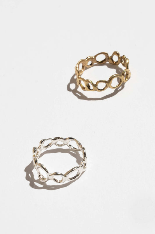 Two gold chain-link rings on a white background. Moneh Brisel Current Ring