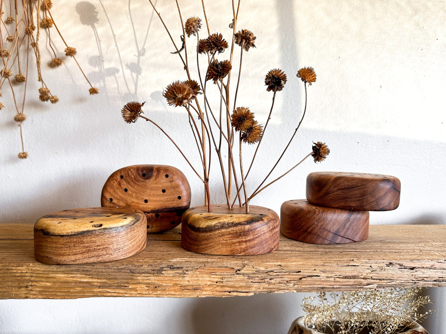 A wooden flower frog made from reclaimed mesquite. These were designed to provide a hint of warmth while giving you the creative play on height, color, texture and "flow" for your florals.