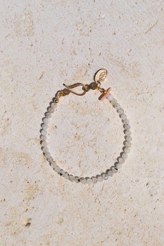 Moonstones metallic white, ethereal energy connects us to the Goddess, Mother Nature & that grounded depth we're all searching for... With coral for an added layer of protection. Designed in California by Carrie Marill and made by hand in her SoCal studio.