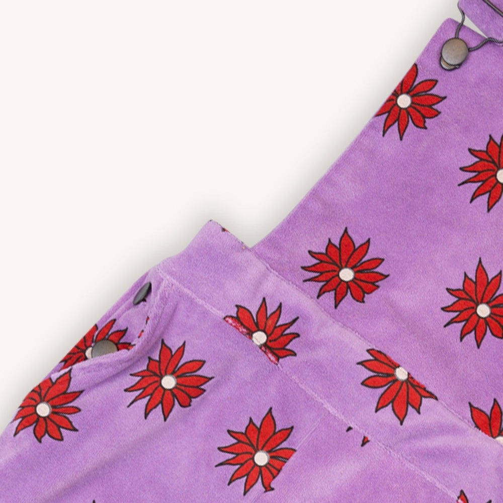 Purple velvet overalls with a red flower print made with 95% organic cotton. Ethically produced, colorful and fun with an eye towards comfort, style and joy. Modern and sustainable kids clothing by CarlijnQ of the Netherlands.