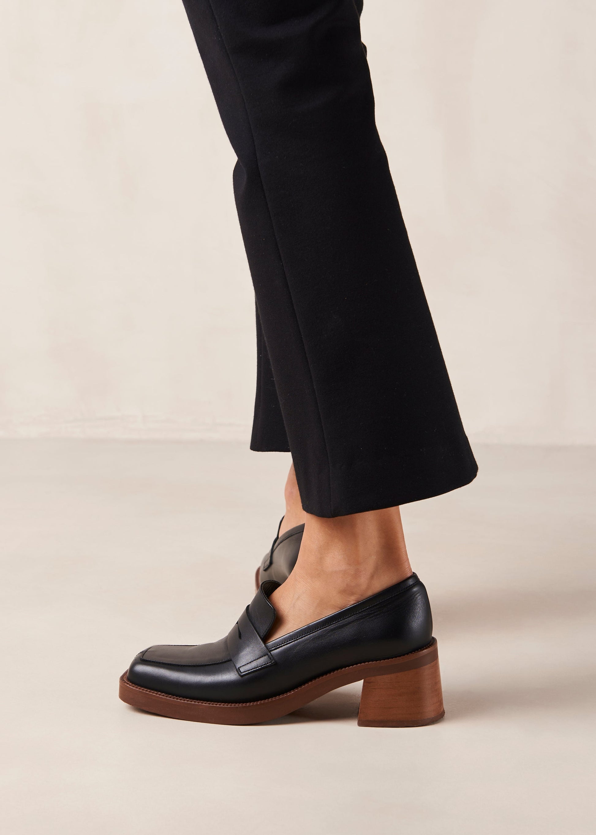 If you are always game for extra height, Roxanne is the loafer-pump hybrid you have been craving for. Think your evergreen moccasin silhouette set atop a chunky block heel for a little flattering elevation. They come in premium black leather and feature the classic penny tab across the vamp. Sustainably made in Spain. Alohas Roxanne Black Leather Loafer.