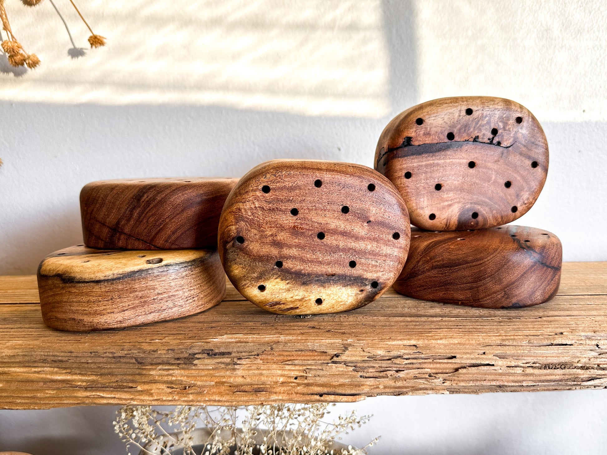 A wooden flower frog made from reclaimed mesquite. These were designed to provide a hint of warmth while giving you the creative play on height, color, texture and "flow" for your florals.