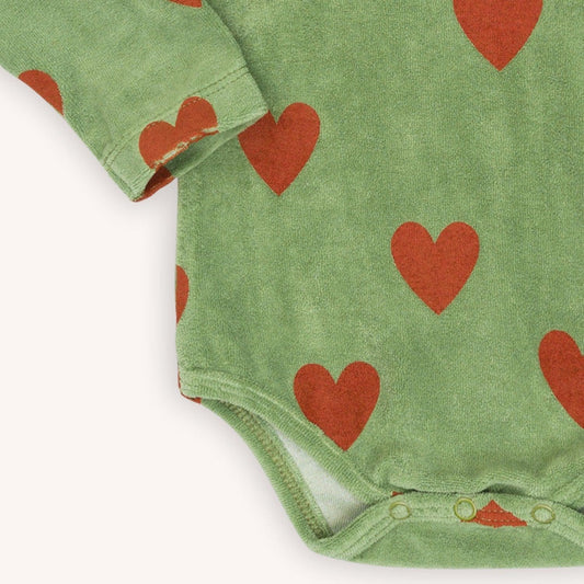 Green velvet long sleeved bodysuit with a red heart print made with 95% organic cotton. Ethically produced, colorful and fun with an eye towards comfort, style and joy. Modern and sustainable kids clothing by CarlijnQ of the Netherlands.
