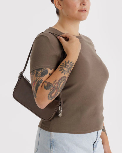 Made from recycled leather, Baggu's sleek Pochette features built-in card slots for organization, a metal smiley face charm, and an adjustable strap.