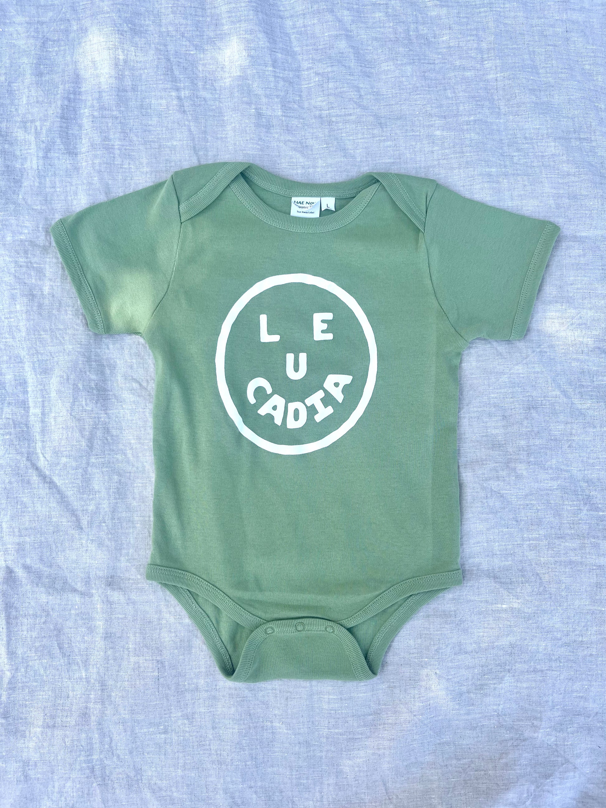 A fun little organic infant onesie with a super cute little Leucadia smiley face by local artist Zach Smith. Printed on an organic cotton, fair trade onesie with all proceeds to San Diego area families facing housing insecurity. Keep it funky, keep it kind, keep it local.