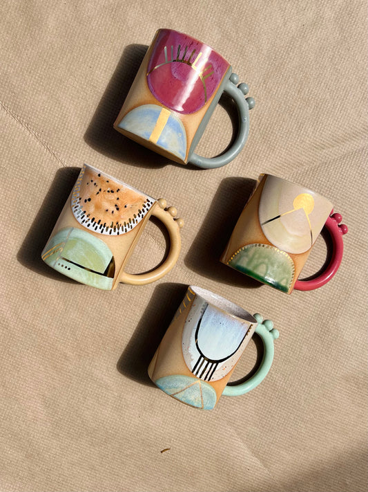 Handmade ceramic mug featuring unique glaze colors & ball accents atop a looped handle. Each is entirely one of a kind, all including gold luster to help you shine all day long. Handmade by Curious Clay in Virginia.