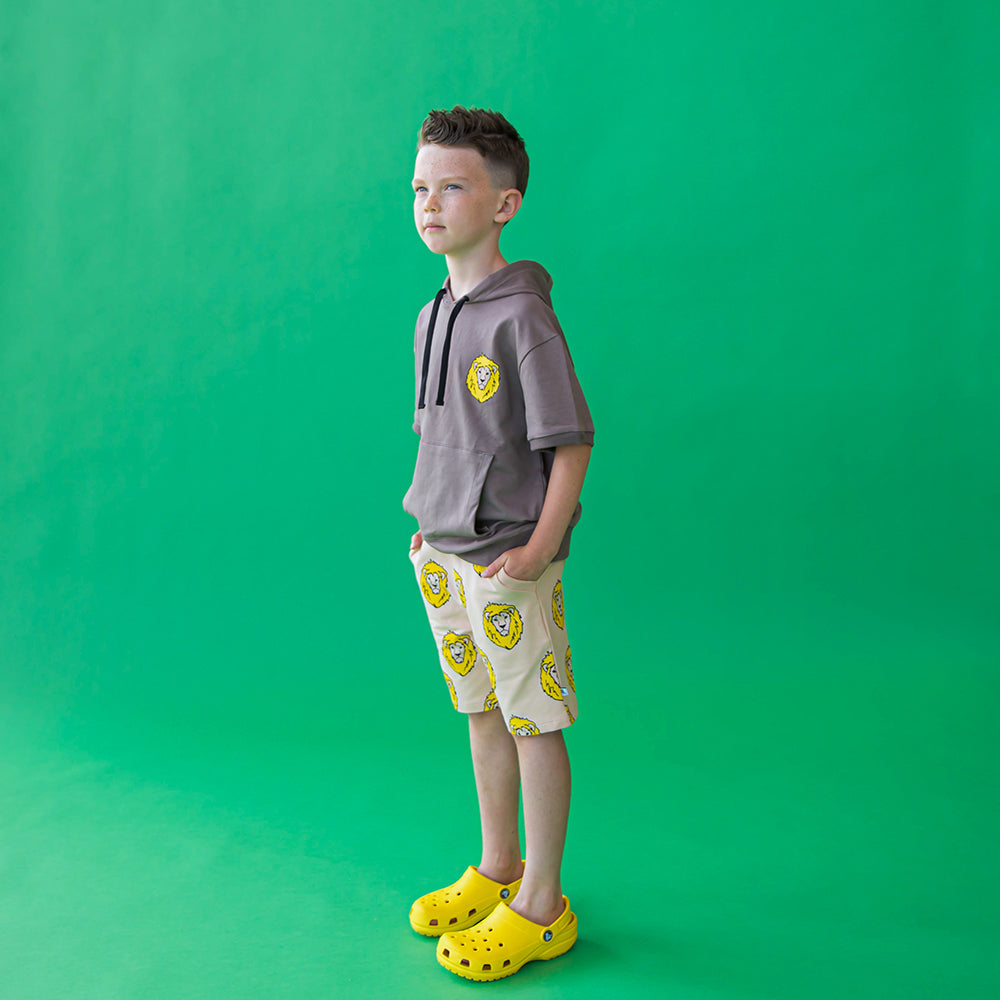 Tan based bermuda style shorts with playful lion print. Ethically produced, colorful and fun with an eye towards comfort, style and joy. Modern and sustainable kids clothing by CarlijnQ of the Netherlands.