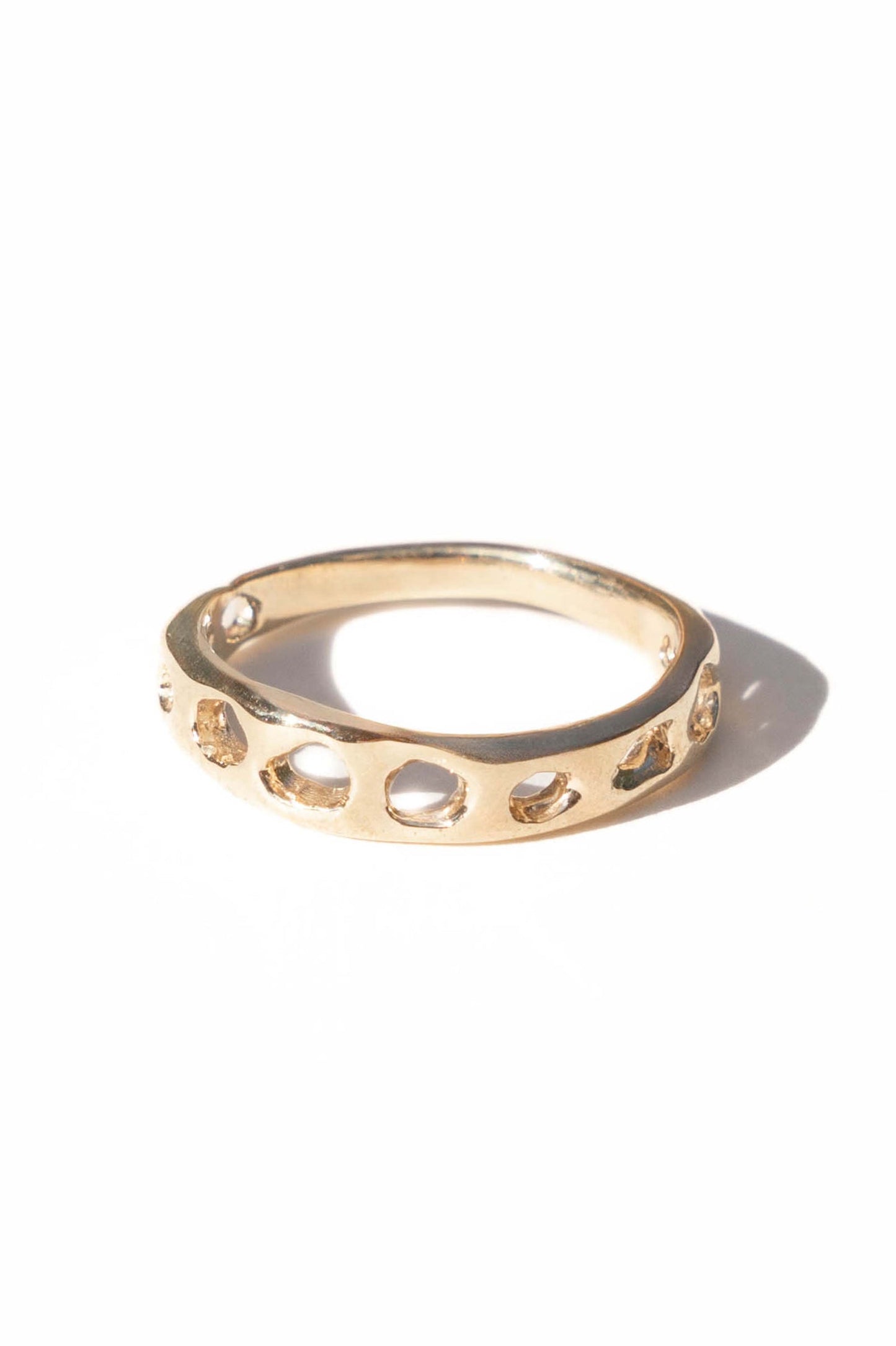 Brass ring by Moneh Brisel with cut-out design on a white background