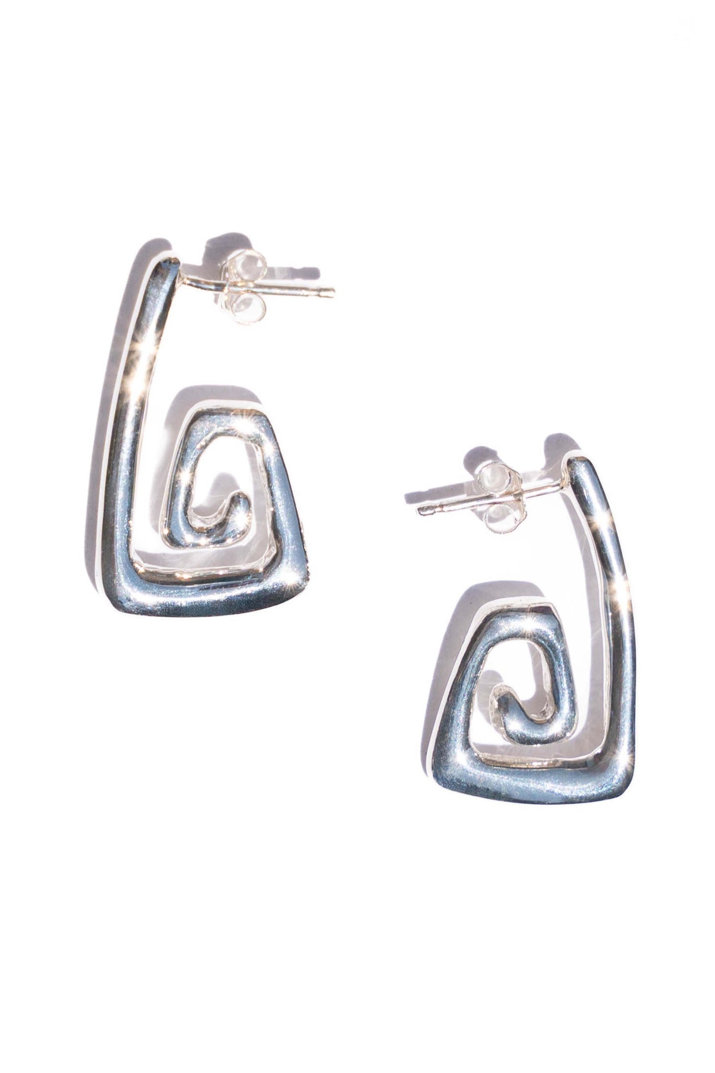 Silver hoop earrings with a wavy design on a white background. Moneh Brisel Nautilo Earrings