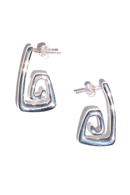 Silver hoop earrings with a wavy design on a white background. Moneh Brisel Nautilo Earrings