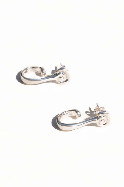 Pair of silver hoop earrings on a white background. Moneh Brisel Espira Earrings