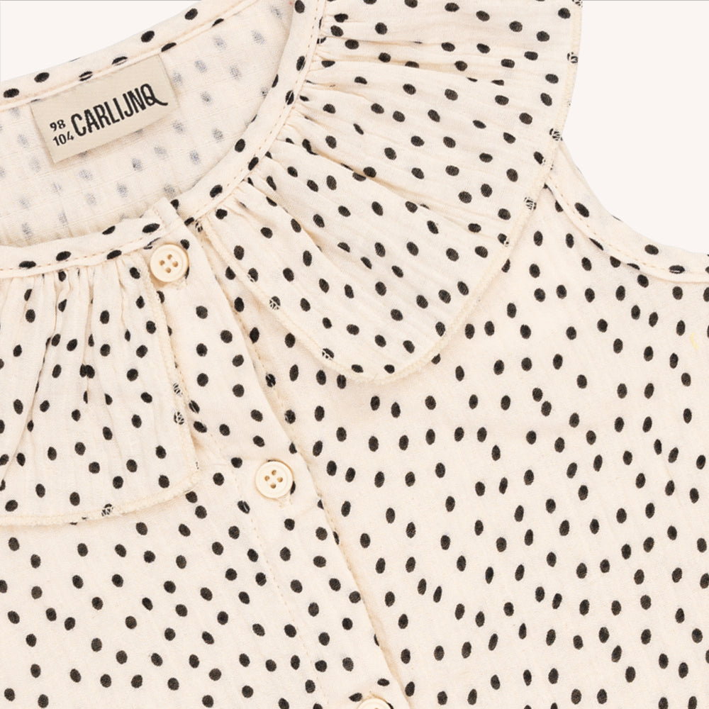 A sleeveless, button down blouse with a ruffled collar and B&W mini polka dot print. Ethically produced, colorful and fun with an eye towards comfort, style and joy. Modern and sustainable kids clothing by CarlijnQ of the Netherlands.
