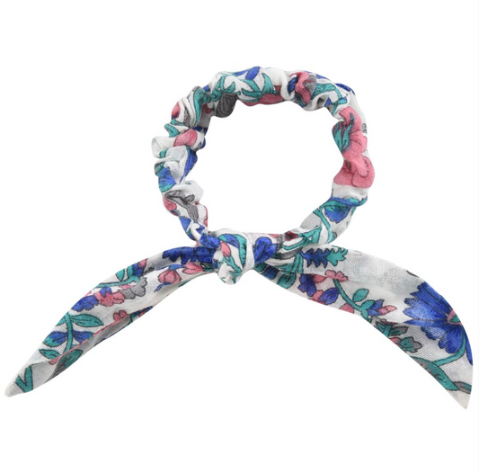 A floral hair scrunchie with a decorative bow. Made with 100% organic cotton. Louise misha chloe scrunchie in blue summer meadow.