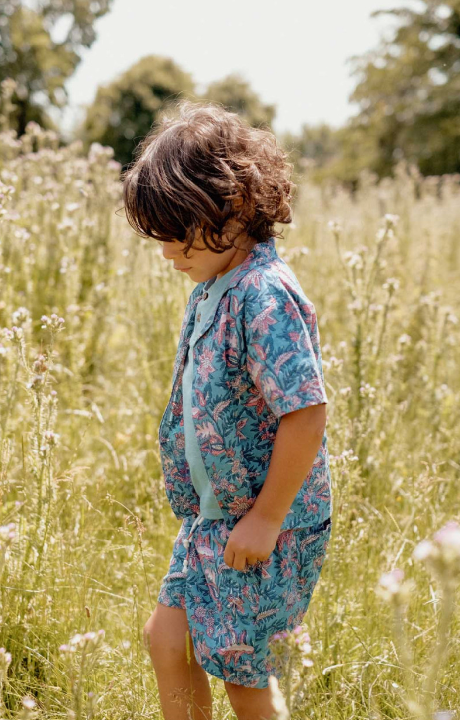 A Hawaiian-inspired short-sleeved cotton veil shirt with an all over print. Made with 100% organic cotton. Louise misha alov shirt in teal garden of eden.