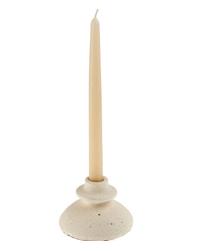 Ceramic candle holder with a white candle on a white background