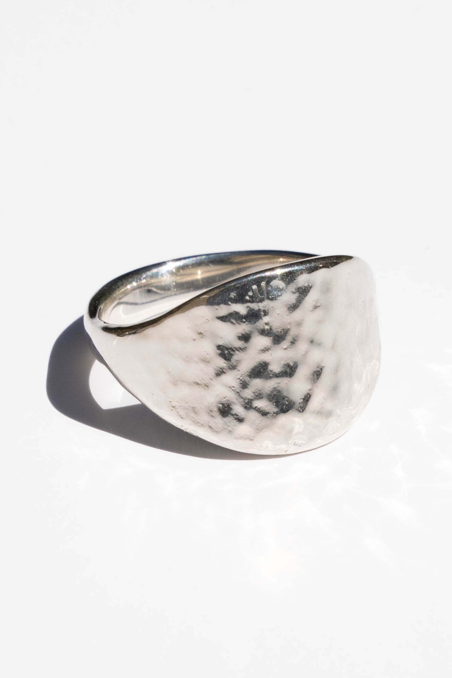 Silver ring with a textured surface on a white background. Moneh Brisel The Sun Ring