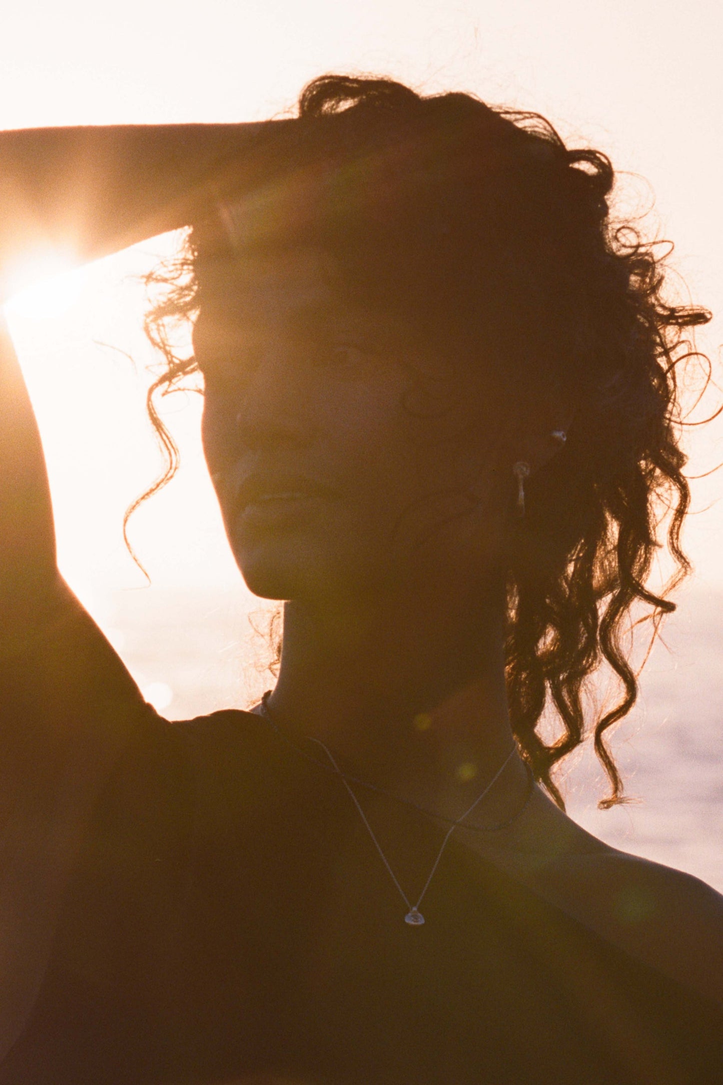 Silhouette of a person with sunlit background. Moneh Brisel Espira Earrings