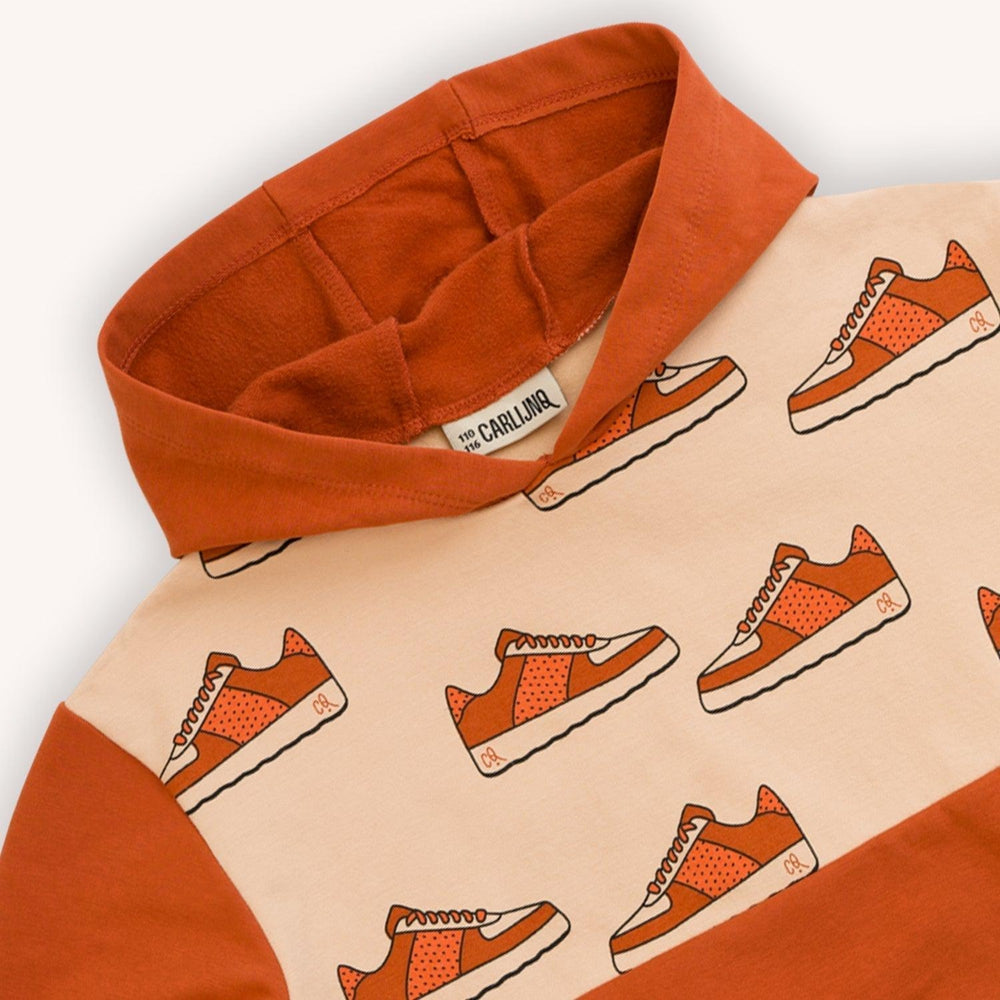 Burnt orange based hoodie with a sneaker print made with 95% organic cotton. Ethically produced, colorful and fun with an eye towards comfort, style and joy. Modern and sustainable kids clothing by CarlijnQ of the Netherlands.