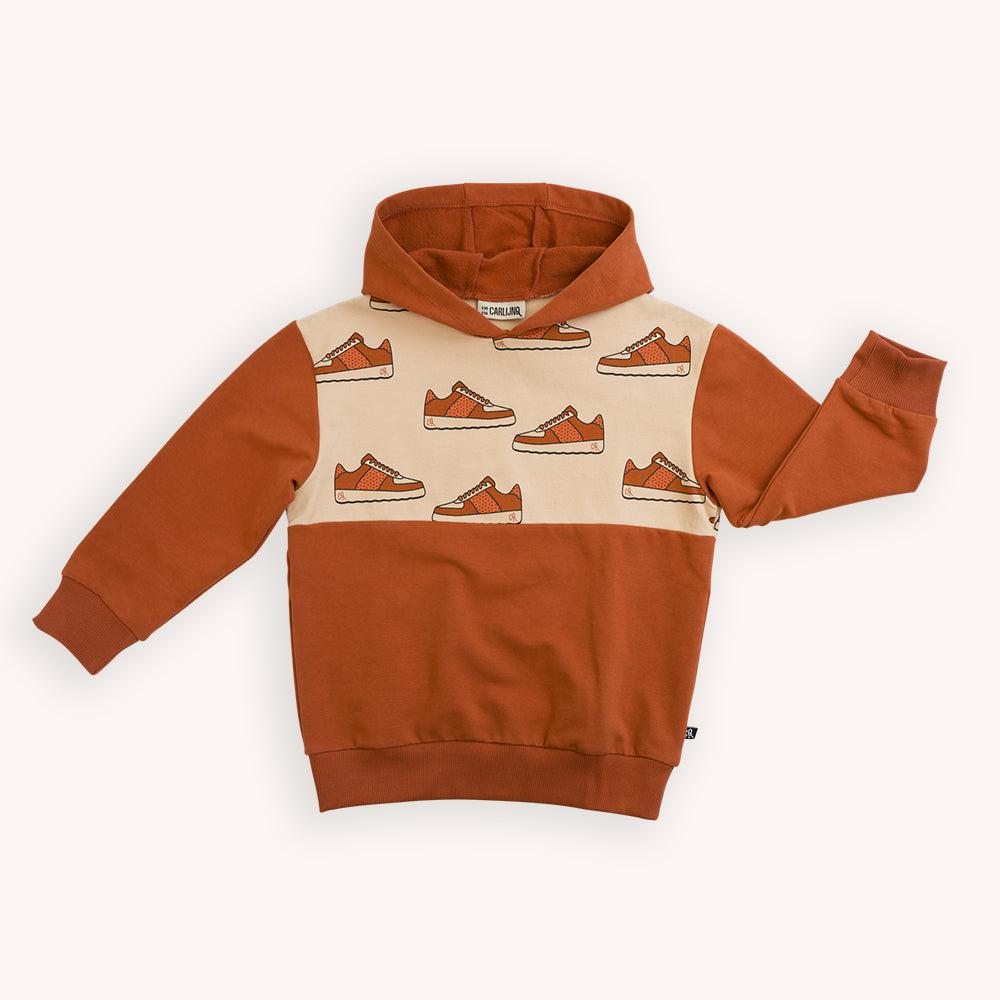 Burnt orange based hoodie with a sneaker print made with 95% organic cotton. Ethically produced, colorful and fun with an eye towards comfort, style and joy. Modern and sustainable kids clothing by CarlijnQ of the Netherlands.