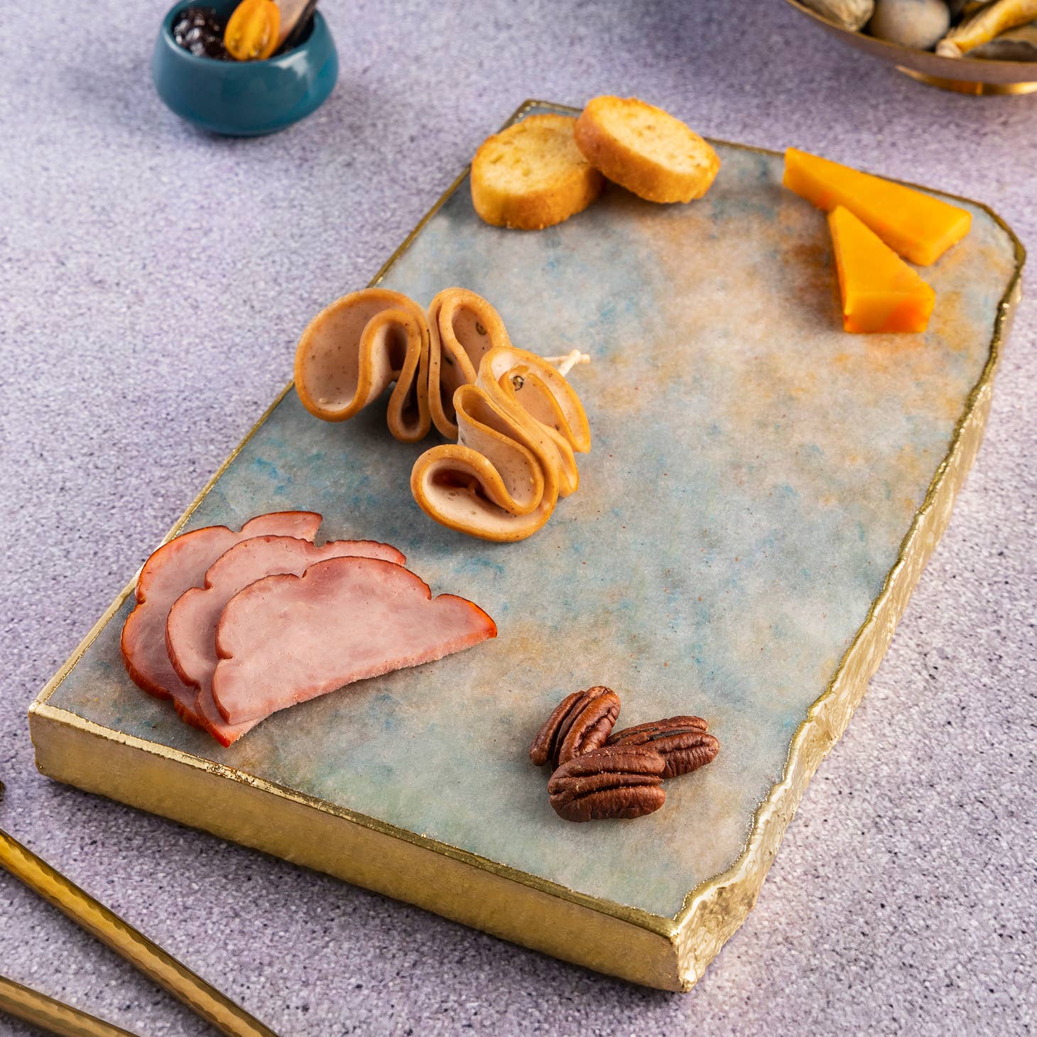 Suitable for use at both formal and informal occasions, this handcrafted aventurine cheese board is gilded with gold edges, & the perfect size to serve an array of options. made in india