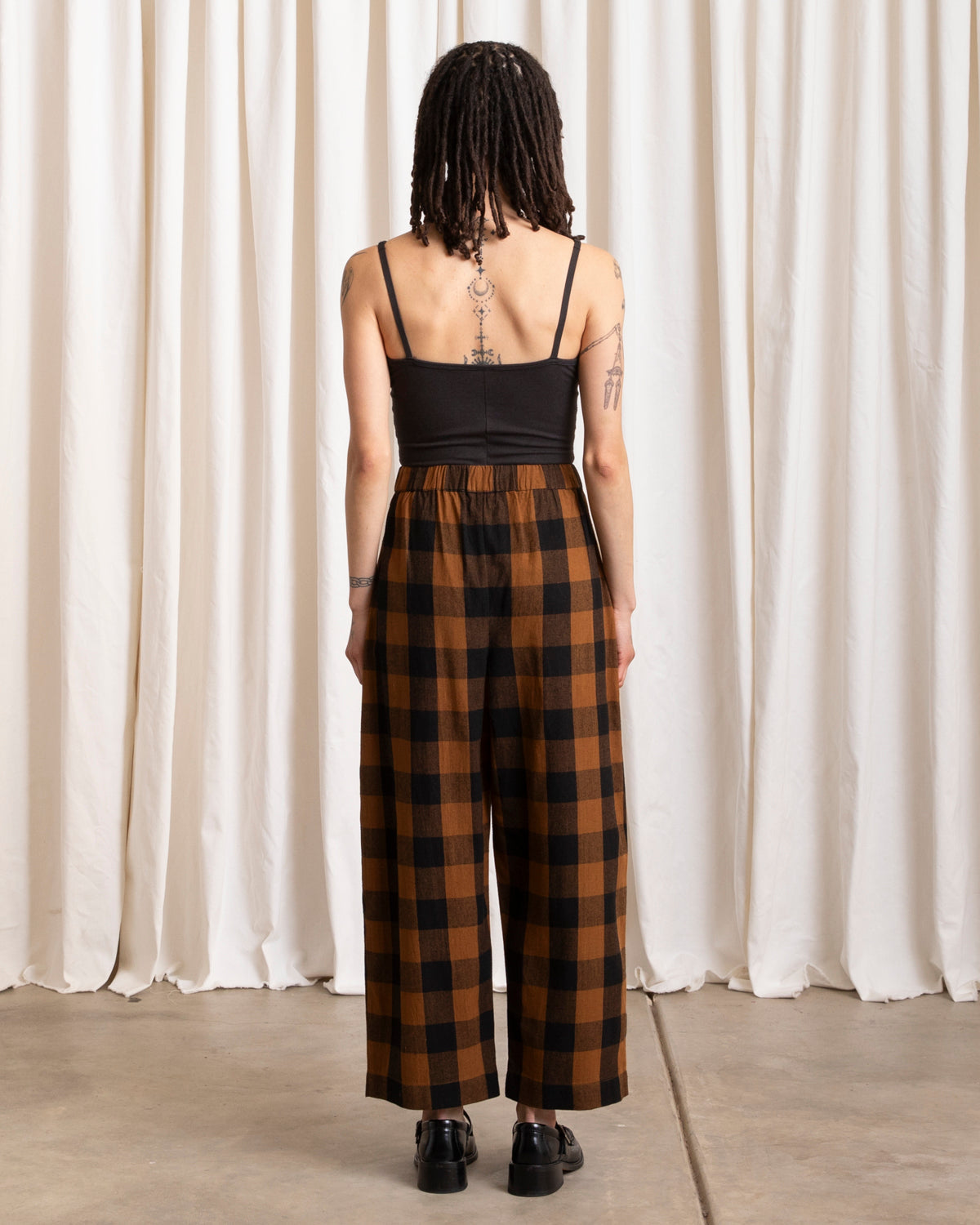 ali golden / An elastic waist pant in raw silk with poppy/pink plaid pattern and barrel pant silhouette.
