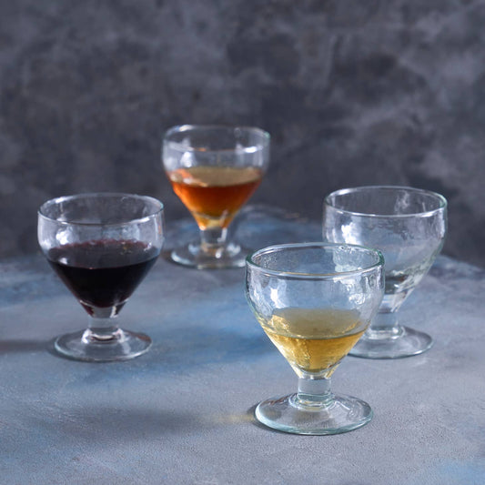 Smaller than a goblet, yet larger than a shot, these footed glasses multitask as water or wine glasses, or as fanciful chalices for milk or juice. Ethically made in India.  