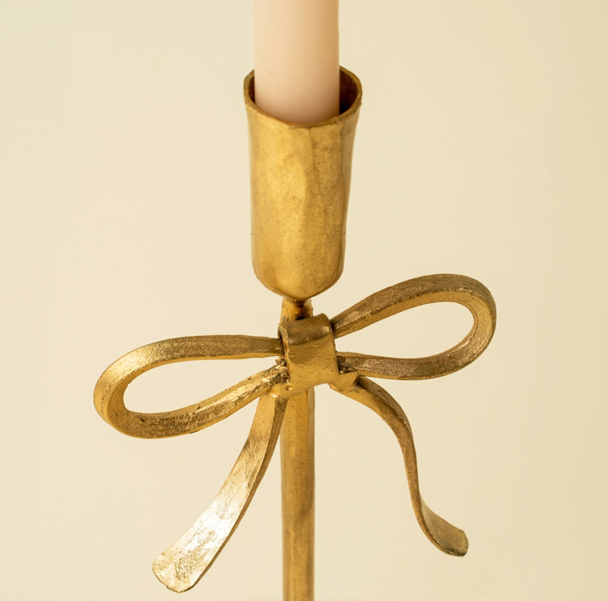 Gold bow candlestick hand forged ethically in India.