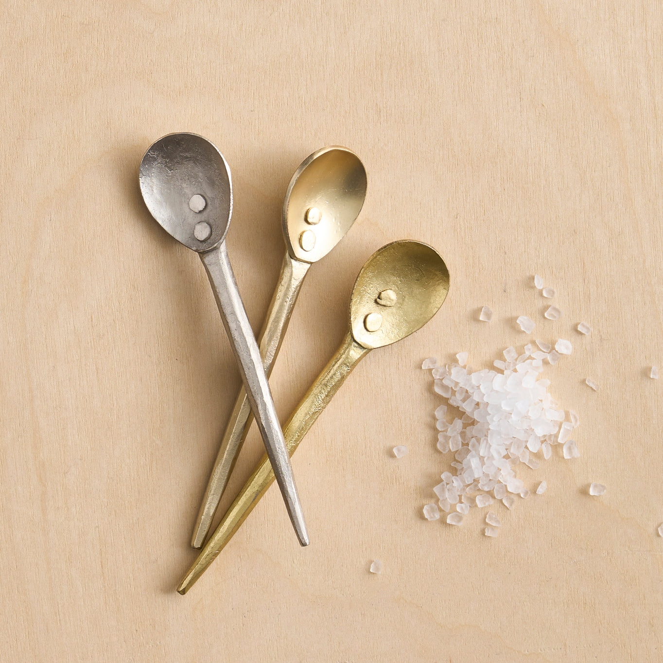 Three small spoons are perfectly sized for serving sauces, jams and sugars, or for stirring your morning brew. Set includes a spoon in each of three different finishes: hammered brass, hammered pewter and smooth satin brass. Crafted from mild steel.