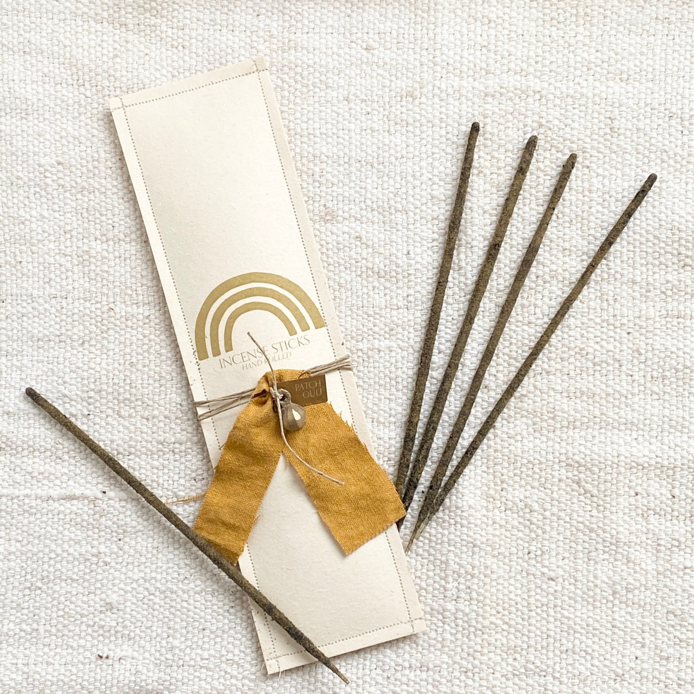 Pack of 12 hand rolled, sandalwood incense sticks. Each pack is wrapped with hemp, vintage fabric, and a brass bell.