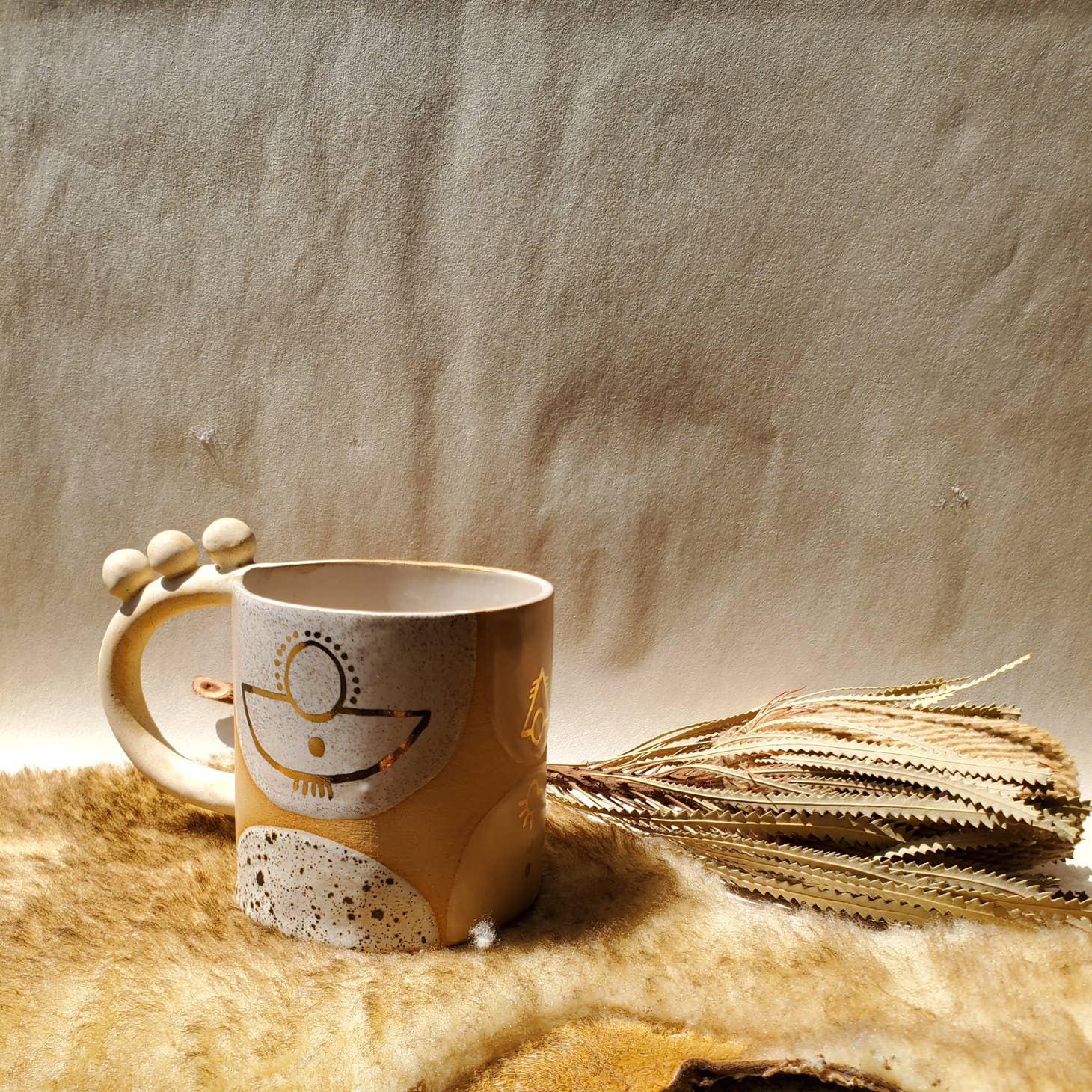 Handmade ceramic mug featuring unique glaze colors & ball accents atop a looped handle. Each is entirely one of a kind, all including gold luster to help you shine all day long. Handmade by Curious Clay in Virginia.